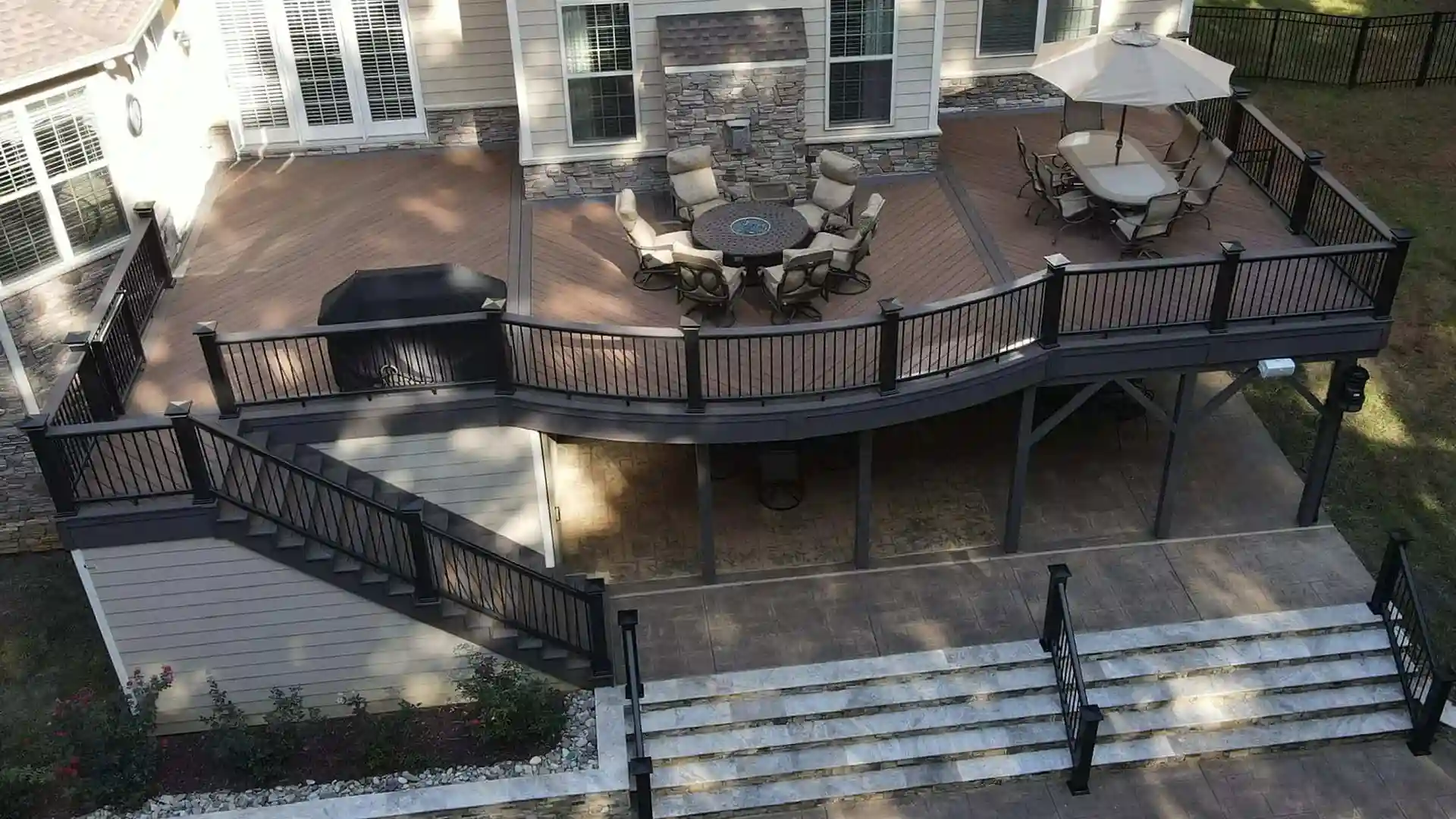 Multilevel brown composite deck with dinning table and chairs