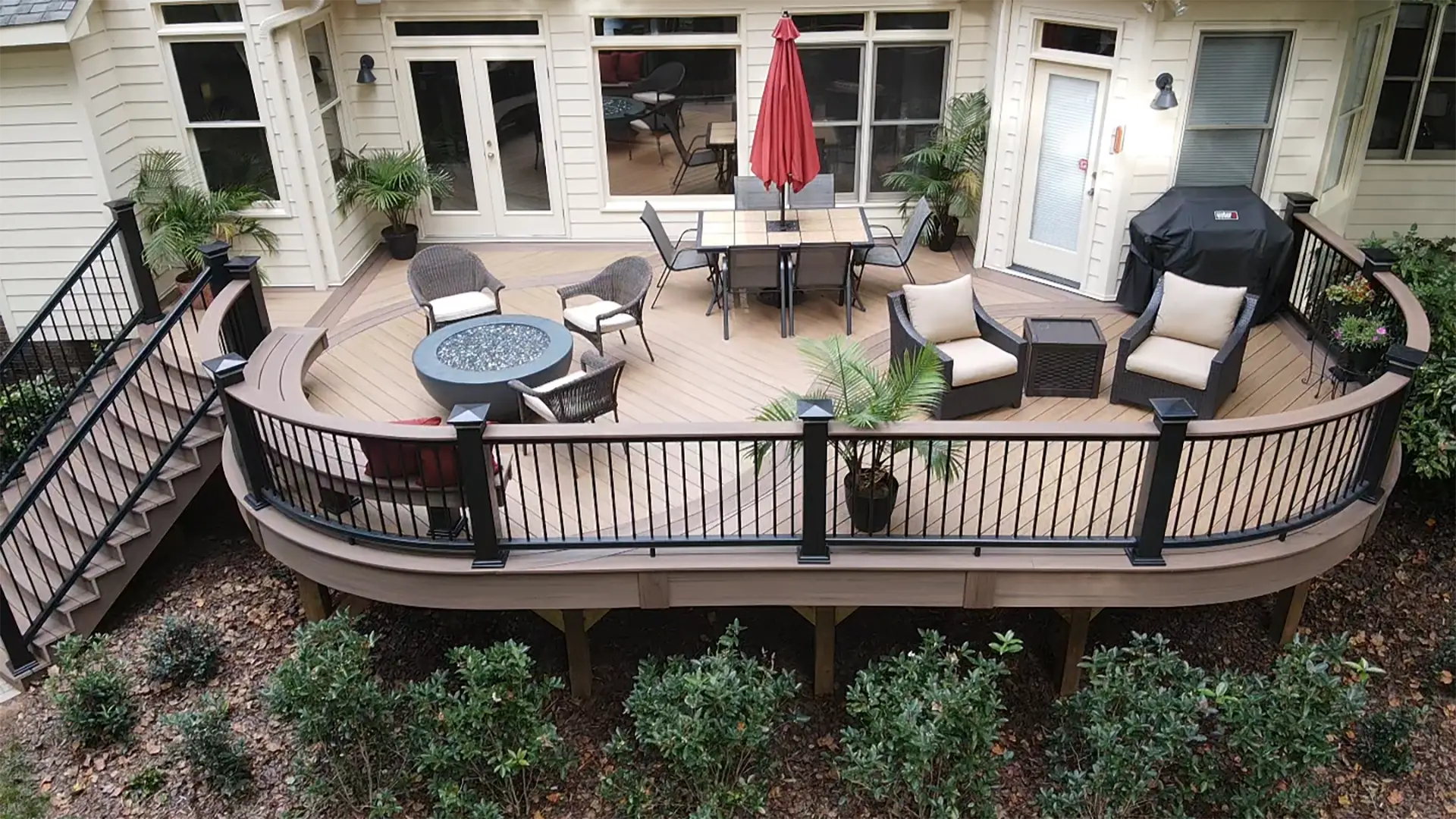Aerial view of a brown curved composite deck with black aluminum railing