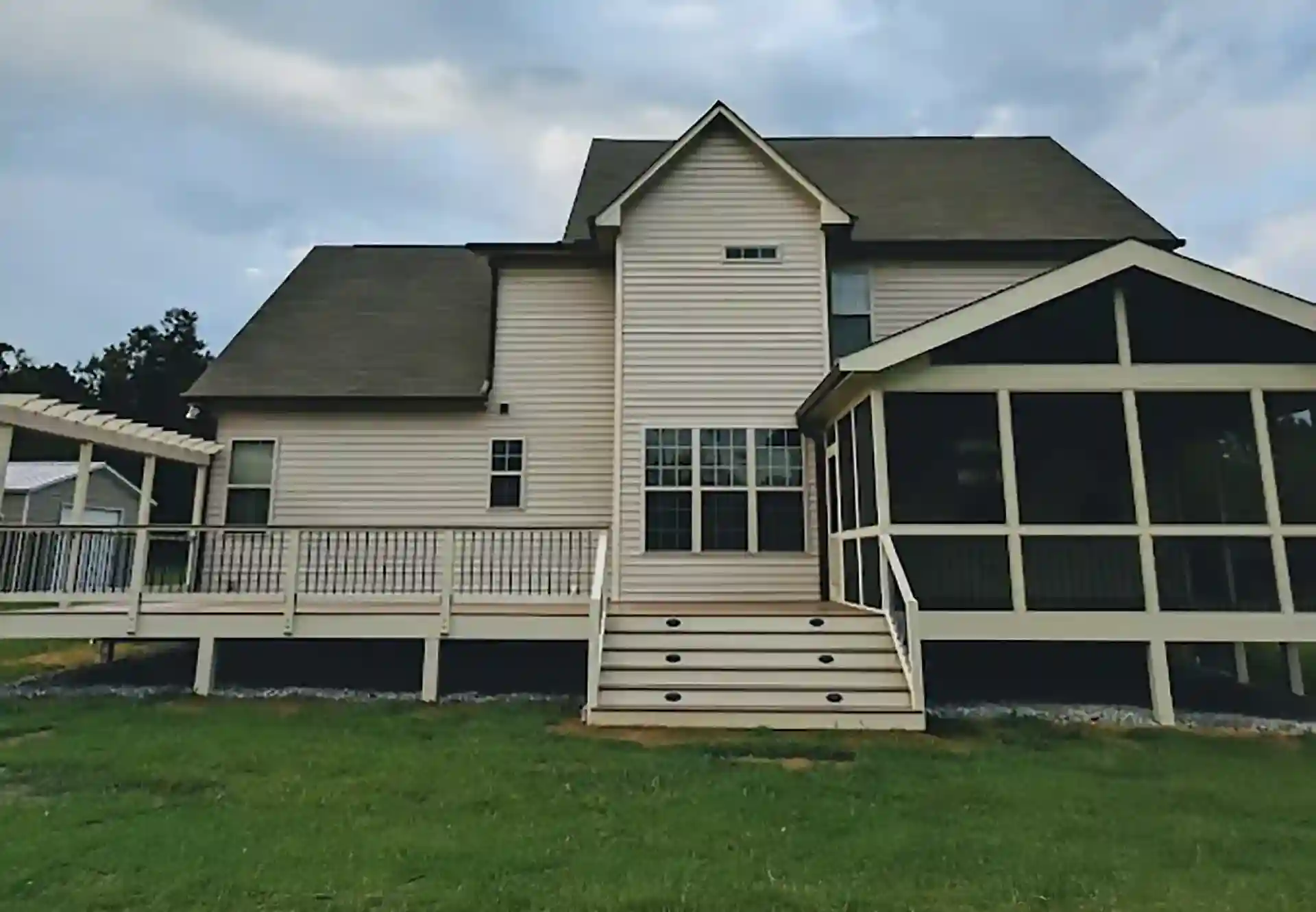 Front view of a beige two story house with a composite deck